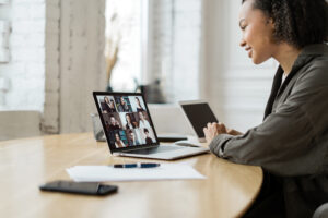 Video communication woman with colleagues freelancer workplace uses laptop computer company report in office coworking space